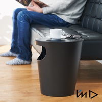 黑色圓筒形儲物垃圾桶置物邊桌，帶有側面開口，桌面擺放著白色咖啡杯、碟子和一副眼鏡。