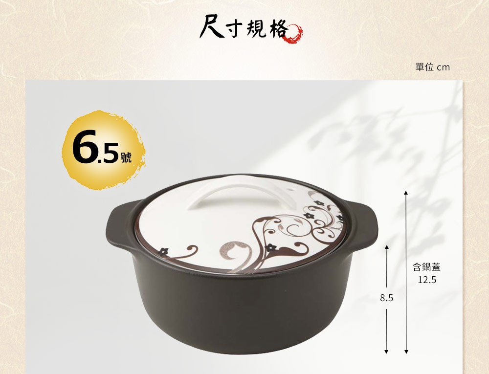 深色陶土湯鍋，帶有白色鍋蓋，鍋蓋上有棕色捲曲花紋圖案，鍋身兩側有黑色提把。