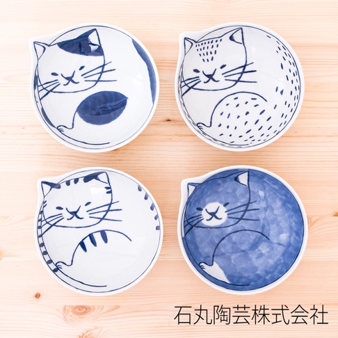 四個陶瓷貓咪飯碗，造型可愛，碗內繪有不同款式的貓咪圖案，顏色以藍白為主，碗身呈現圓潤的弧度，適合盛裝寵物食物。