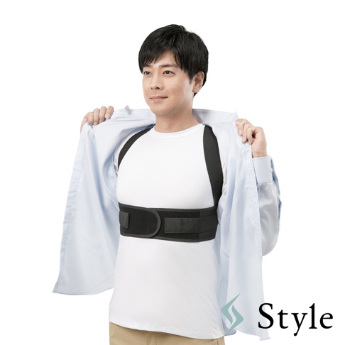 一位男性穿著白色T恤，外搭一件淺藍色襯衫，露出胸前的黑色美姿調整背帶，背帶由兩條肩帶和一條腰帶組成，腰帶上有魔鬼氈黏貼。