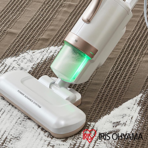 白色與米色機身的無線吸塵器，配有透明集塵筒，內有綠色燈光。吸塵器頭部有「POWER ADVANCE SYSTEM」字樣。產品置於棕色織物表面，有白色粉末被吸入。