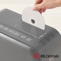 手正在將一張光碟插入灰色碎紙機的進紙口，碎紙機上印有IRIS OHYAMA的品牌標誌。