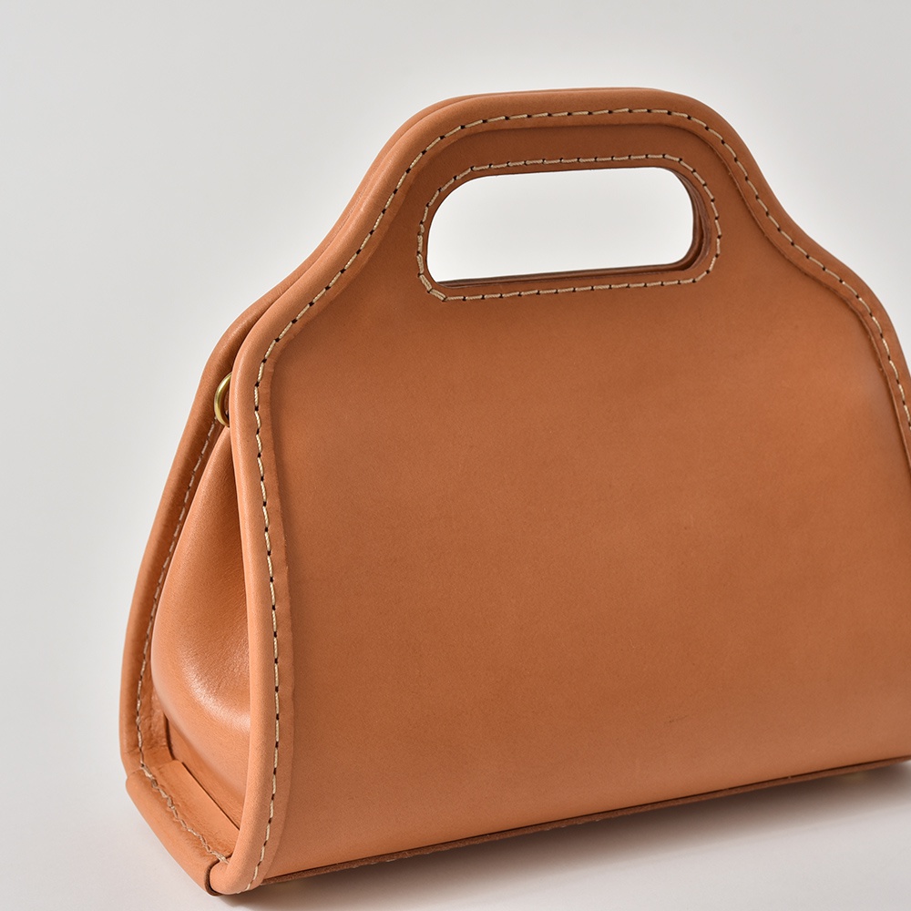 職人手作皮革單肩兩用拱型手袋，採用光滑棕褐色皮革製成，配有對比色縫線和頂部提把。