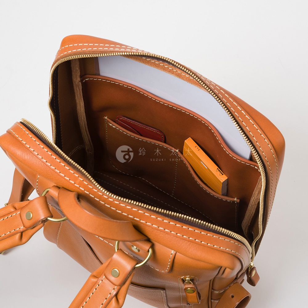 職人手作皮革軟皮商務後背包 R-28，淺棕色皮革，內有隔層、卡槽，可放置文件與小物，搭配金色拉鍊與五金配件。