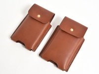 兩個棕色皮革三用手機收納包，採用縫線工藝，每個正面皆有一個金色按扣。