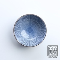 藍染千段十草飯碗，陶瓷材質，碗內佈滿細密的藍色十草紋樣，由碗心向外輻射，碗緣為深棕色。