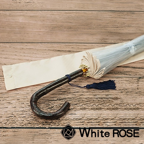 職人高級樺木透明傘，傘柄為深色彎曲樺木材質，搭配深藍色流蘇，傘面為透明塑膠，並附有米白色傘套。