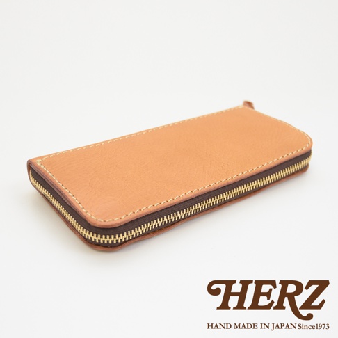 駝色皮革職人手作經典拉鍊長夾，採用天然皮革材質，搭配黃銅色拉鍊，車縫線清晰，展現精緻工藝。
