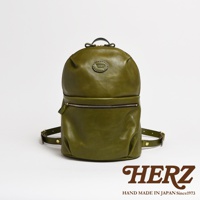 橄欖綠皮革大開口圓角後背包，有兩個外部拉鍊口袋，頂部有提把和品牌標誌，背帶為皮革材質。