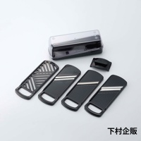 四合一刨絲器，包含一個黑色收納盒、一個黑色刀片保護蓋，以及四個不同刀片的黑色塑膠刨絲板，其中三個刨絲板帶有金屬刀片，刀片上可見白色條紋。