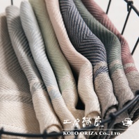 一堆純亞麻斜紋織法的廚房拭巾，呈現米白、淺藍、淡綠、粉紅、深藍、墨綠、磚紅等多種柔和色彩，材質觸感細緻。