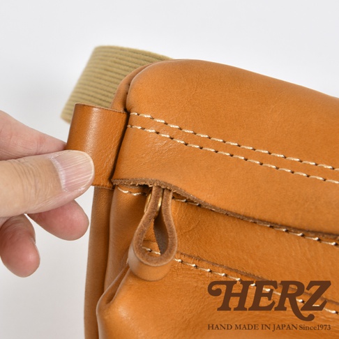 職人手作皮革兩用腰掛斜背包，棕色皮革材質，細緻車縫線，配有皮革拉環的拉鍊，以及可調節的米色織帶。