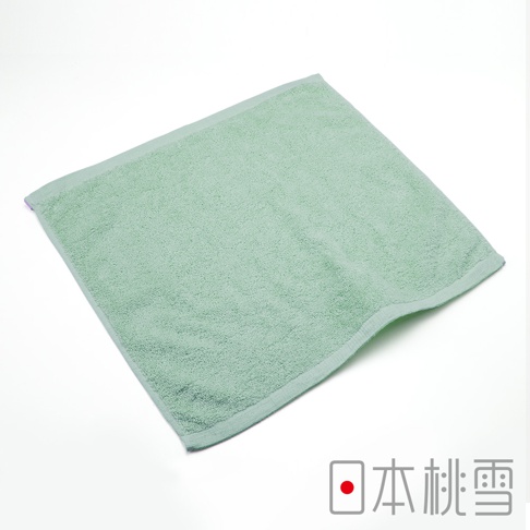 淺綠色飯店方巾，棉質，柔軟親膚，邊緣有細緻縫線，角落處有紫色標籤。
