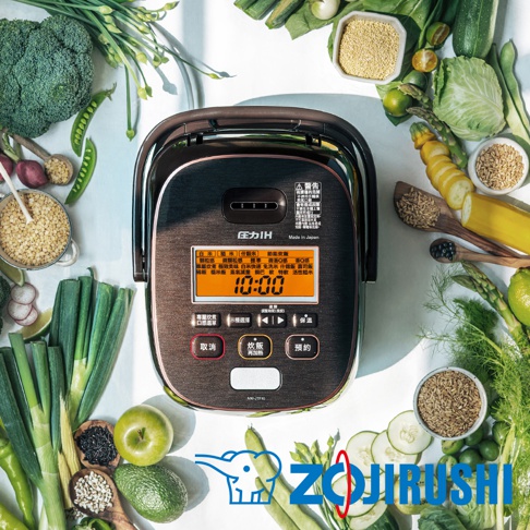 鐵器豪熱羽釜壓力IH電子鍋，帶有黑色鏡面外殼、銀色邊框及LED顯示螢幕，螢幕顯示時間為10:00。電子鍋周圍擺放著多種新鮮蔬菜、穀物和水果，營造健康烹飪的氛圍。