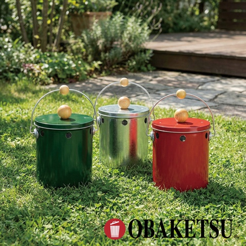 模式B： 綠色、銀色和紅色OBAKETSU蚊香桶並排放在草地上，每個桶都有一個金屬把手和木製裝飾。