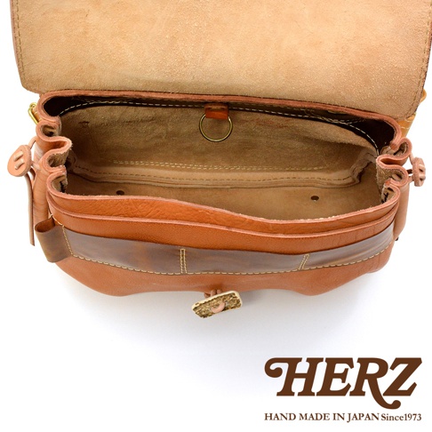 職人手作皮革鹿角扣繩郵差包，棕色皮革，打開狀態，展示內部空間，有縫線細節與金屬環，包款有鹿角造型的扣飾。