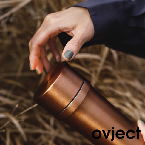 銅色金屬三用保溫瓶，瓶身光滑，帶有細緻的黑色飾條，由手部握持。