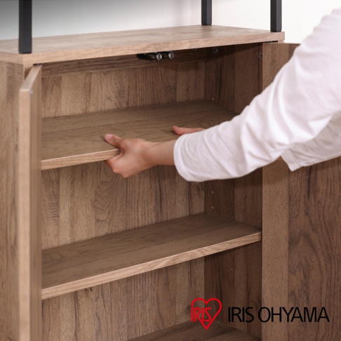 淺木紋色鐵木材質櫥櫃，展示一隻手正在調整中間層板，櫥櫃內有兩層層板，頂部有黑色金屬支架。