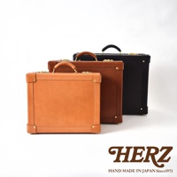 三款職人手作皮革英倫風便攜手提行李箱，分別為淺棕色、深棕色及黑色，配備金色金屬扣件與皮革提把。