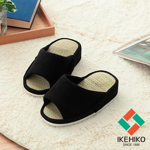一雙黑色藺草內裡室內拖鞋，鞋面為織物材質，露出腳趾，鞋底為白色。