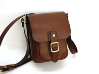 職人手作皮革皮扣直式單肩包，咖啡色皮革製成，有金屬皮扣和可調節式肩帶。