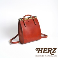 棕色皮革復古口金後背包，採用高品質皮革製作，配有黃銅色口金鎖扣、可調節肩帶和頂部提把，展現職人手作質感。