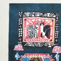 無框帆布藝術印刷品，描繪一幅帶有兩隻貓咪圖案的掛毯，背景為深藍色，下方有兩個帶有紅色幾何圖案燈罩的檯燈。