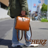 職人手作皮革迷你後背醫生包，採用光滑焦糖棕色皮革製成，配有金色鎖扣和可調節皮革肩帶。