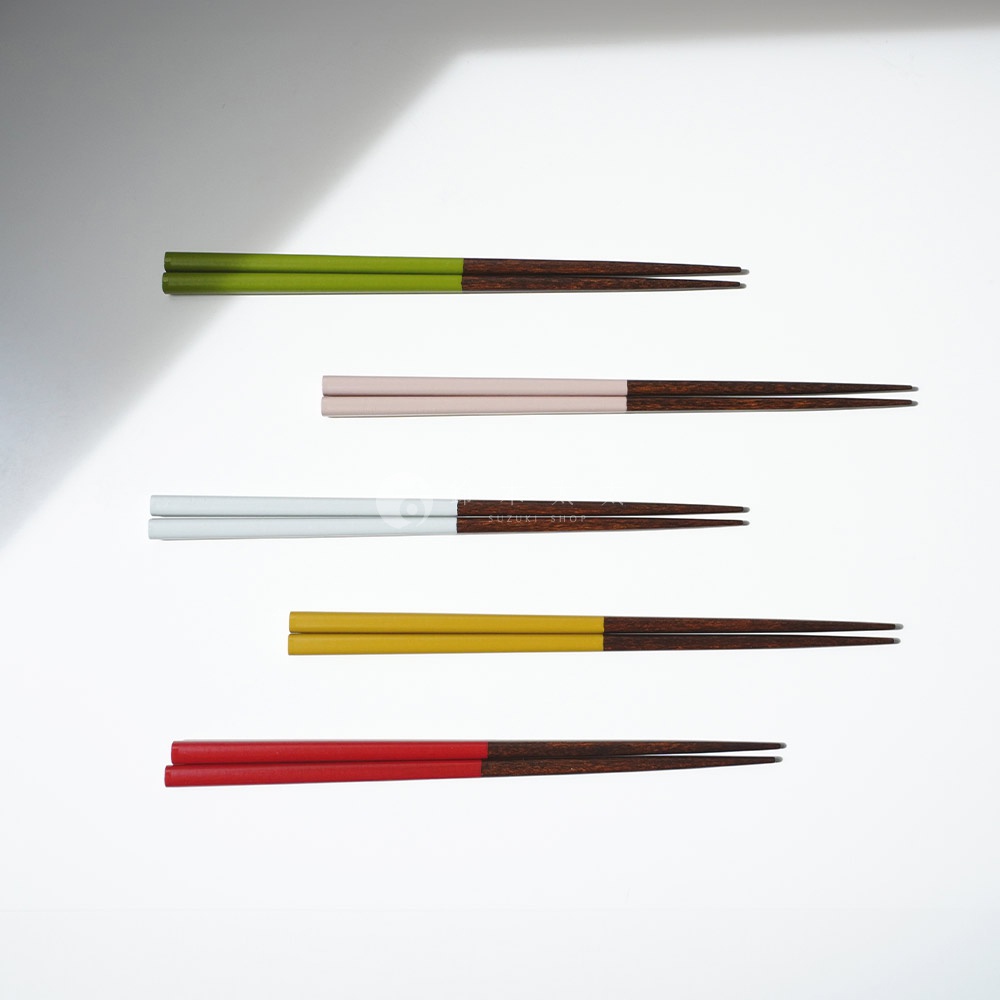 一組五雙23公分長的木筷，頂端分別為綠色、淡粉色、白色（帶有黑色文字）、黃色和紅色。筷子下半部為深棕色木紋。