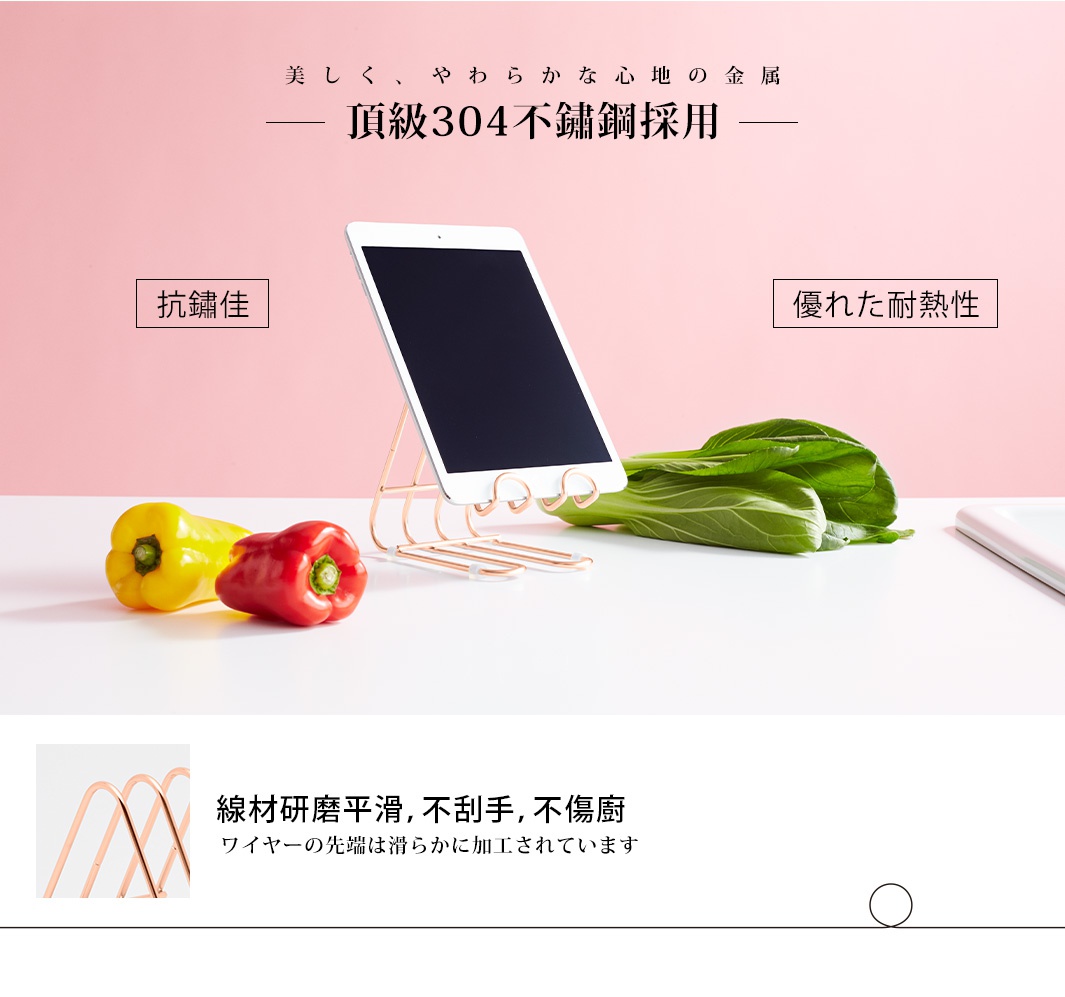 玫瑰金色不鏽鋼萬用支架，以線條造型支撐著平板電腦，旁邊擺放著黃色甜椒、紅色甜椒及青江菜。