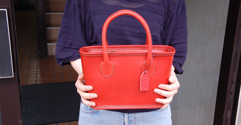 職人手作皮革輕巧散步手提包，鮮紅色，拉鍊開合，雙提把設計，附有同色系皮革吊牌。