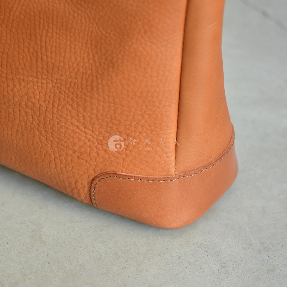 職人手作皮革Organ兩用商務托特包 G-61，特寫展示包款的底部邊角，採用兩種不同色澤與紋理的棕色皮革拼接，車縫線清晰，材質質感細膩。