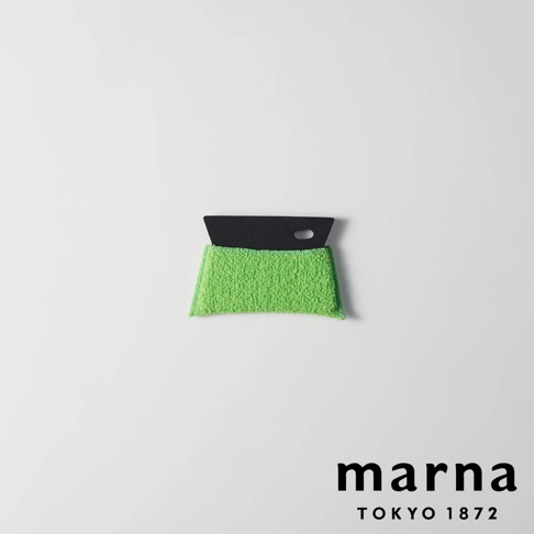 marna TOKYO 1872 品牌標誌旁，是一個綠色毛巾材質，搭配黑色刮刀的清潔工具。