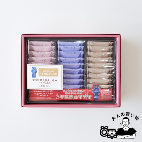 一盒粉色、紫色和米色的 Colombin 巧克力夾心餅乾禮盒，上面印有金色獎項的標籤。