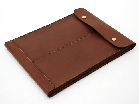 職人手作皮革信封式雙釦手拿袋，採用溫潤的棕色皮革製成，設計簡潔，正面有對稱的縫線裝飾，並以雙金屬按釦固定。