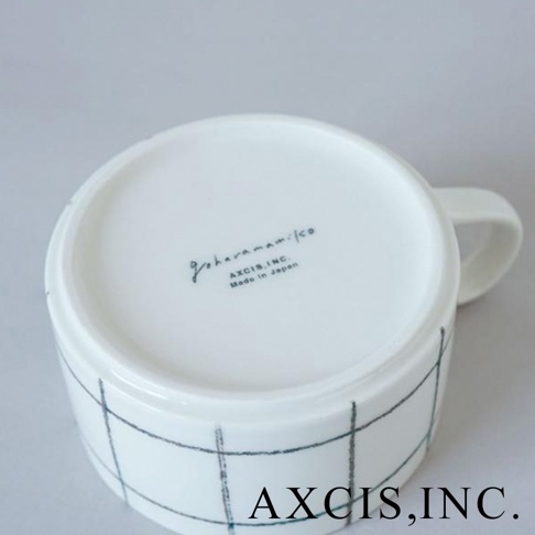 白色美濃燒手繪馬克杯，杯身帶有藍色網格線條，杯底有品牌標誌與「Made in Japan」字樣。