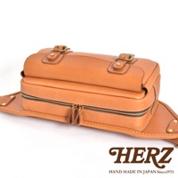 職人手作皮革騎士隨身斜背包，以棕色皮革製成，配有雙拉鍊開口、兩個搭扣裝飾，風格簡約實用。