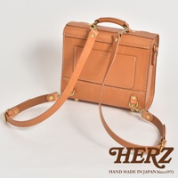 棕色皮革製成的迷你三用後背包，具有學院風格設計，包身有縫線細節與金屬釦件，可肩背或後背，正面有品牌燙印Logo。