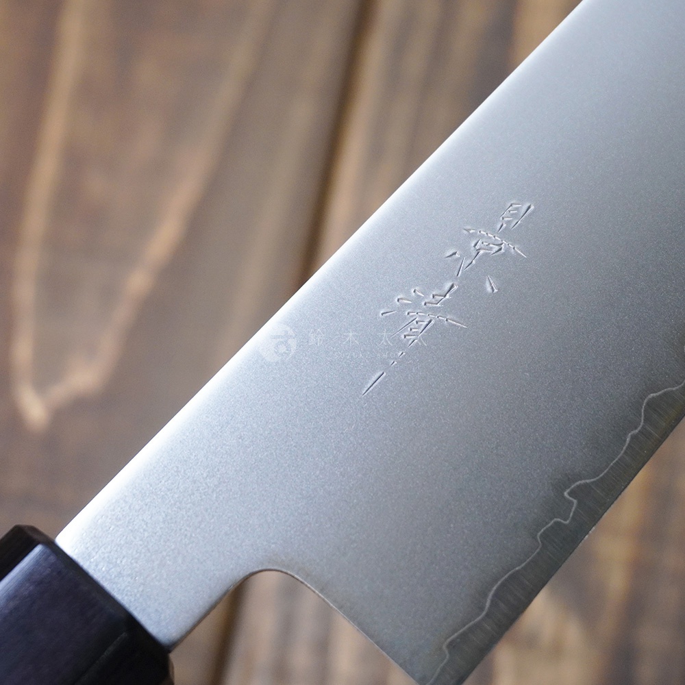 [景清] Chromax鋼三德刀-胡桃木18cm，刀刃為銀色Chromax鋼材質，帶有壓印的品牌標誌和紋理。刀柄為深棕色胡桃木材質，靠近刀刃處有金屬連接。