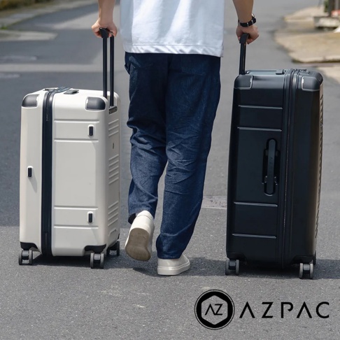兩款AZPAC Trucker 2.0 26吋旅行箱，一款為奶茶色，另一款為黑色。兩款皆為防爆設計，擁有可伸縮拉桿和四輪設計，材質為硬殼。