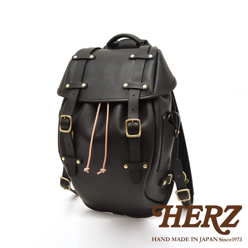 黑色皮革經典雙扣後背包，配有兩個可調節搭扣和抽繩閉合，側邊有金屬細節，適合日常使用。