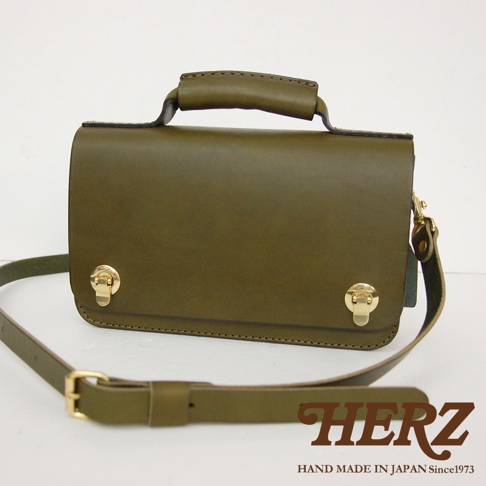 橄欖綠皮革迷你單肩包，配有頂部提把、雙金屬旋扣和可調節肩帶。