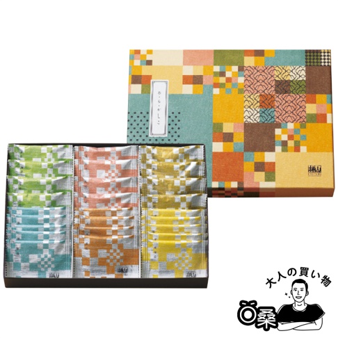 這是一盒精緻的日本和菓子禮盒，採用方格拼接風格的彩色紙盒包裝，內含三排排列整齊的獨立包裝糕點，包裝袋分別為綠色、橙色與黃色調的幾何花紋設計，右下角有一個繪製成卡通形象的男子線條畫與文字圖示。