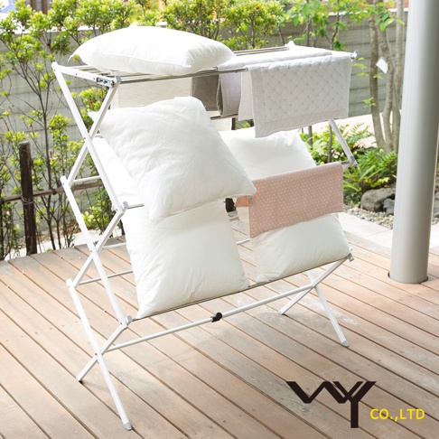 WY 菱形多桿晾曬架，上面擺放了幾個白色枕頭和兩條毛巾，其中一條粉色毛巾上有白色圓點。