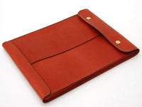 橘紅色皮革信封式雙釦手拿袋，以精緻車縫線勾勒出簡約造型，金色釦子增添質感。