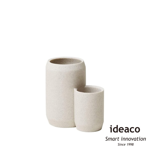 一對米白色砂岩材質的廚具收納筒，一個較高，一個較低，呈現簡約的圓柱形設計。