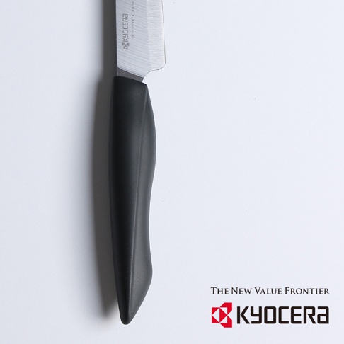 一把黑刃精密陶瓷刀，刀刃部分為銀色金屬材質，有「KYOCERA advanced ceramic」字樣；刀柄為黑色，採用人體工學設計。