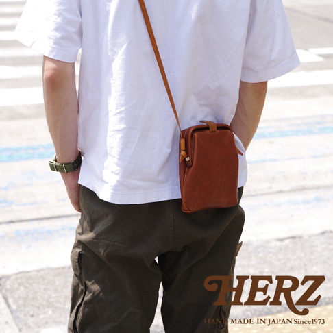 職人手作皮革Organ迷你杜勒斯側背包，呈現自然的棕褐色，採用柔軟的皮革材質，搭配細長的同色系皮革背帶，包款設計簡約，適合斜肩或側背。