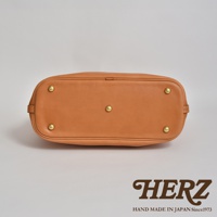 職人手作皮革大容量兩用托特包 T-8，展現自然色澤的皮革材質，底部設有四個金屬腳釘，穩固耐用。