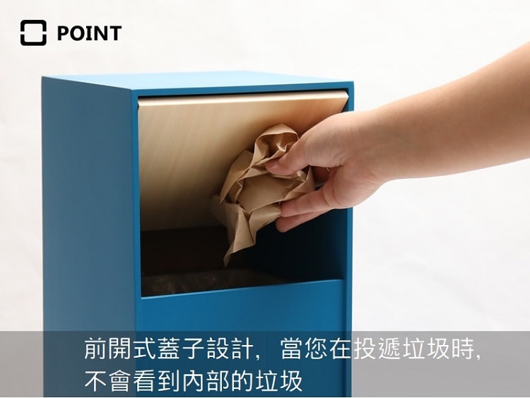 藍色純手工木製迷你垃圾桶，前開式木質蓋子，可見一只手正在丟入紙團。